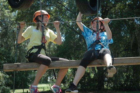 Juniors Caitlyn Helms (left) and Meghan Curing (right) test their teamwork skills on Dayspring's newest rope challenge. With tires and small ladders, this difficult activity requires teams of two to climb up the swinging tires and scale the ladders to reach the top of the structure. Photo Credit: Haley Palumbo (used with permission)