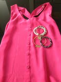 Some of The Looks jewelry and a vibrant pink shirt.