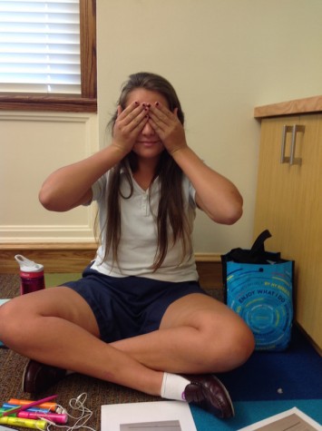 “I usually put my lunch box under my desk because that makes it out of sight and out of mind” Junior Gabbie Regano poses as a ‘see no evil’ emoji, so she can ‘see no lunch.’ Photo Credit: Grace Toups