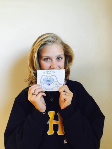 Senior McKenzie Miller holds the final product of the sticker. Credit: Jacqueline Brooker