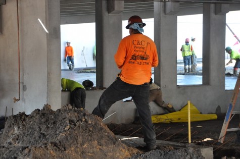 Construction workers filling in the bottom level pavement of the parking garage. PhotoCredit: Riley Gillis