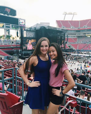 Gillian rocks a striped red tee paired with black shorts alongside a friend at the concert.