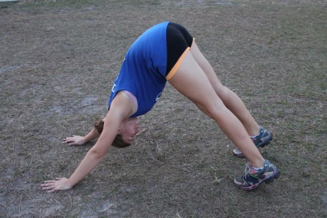 (Photo credit: Keri Kelly) Junior Abby Morris demonstrates "downward dog" which stretches your shoulders and hamstrings.