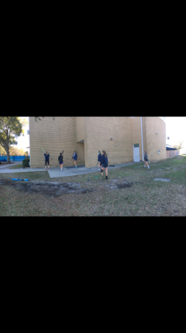 LAX girls warming up before their big tryout. The players practice throwing the ball on the wall and catching it with their sticks.