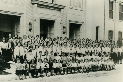 Group of students gathered around the front of the school in 1931.