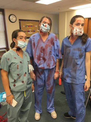 Seniors Anna Padron, Abby Morris, and Ally Wehle played convincingly evil doctors, thanks to Traud and her makeup team. Photo Credit: Alex Smith/Achona Online