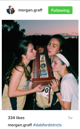 The seniors kissing their last trophy of the season